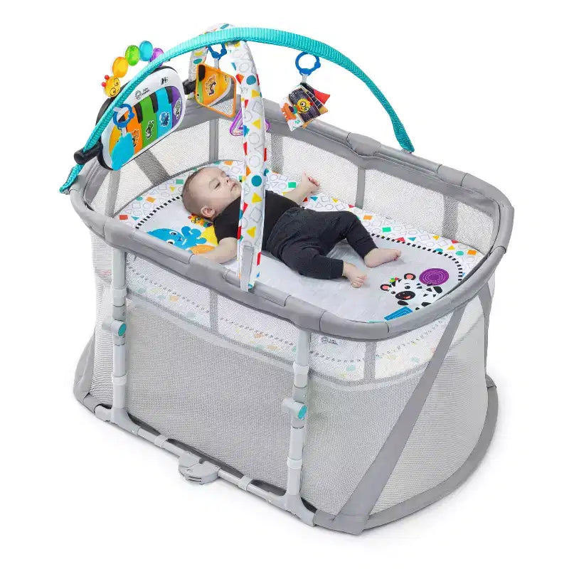 Lit de jeu Kick & Snooze de Baby Einstein avec drap-housse ovale : Cadre en acier, garnissage en coton, capacité de 22,7 kg